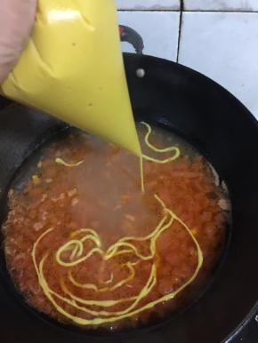 裱花袋剪一个小口，把面糊均匀的挤到锅里。记得要开大火哦，边挤边煮，面条入锅就会快速凝固，如果面糊调的太稀或者火小了就变成面疙瘩啦。