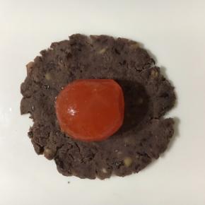 这时可以把馅包起来！取20g左右的红豆沙，包住一个蛋黄。搓圆！