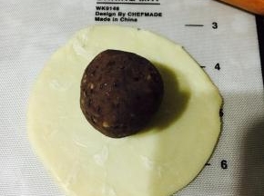 放入馅料，以推的手法将面皮推至收口处，收紧收口！这样做出来的蛋黄酥底层就不会太厚，影响口感！