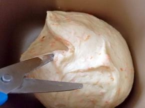 继续放入面包机，开启和面程序，期间用剪刀在面团上剪一下，大约剪十下左右，为了面包更好的排气