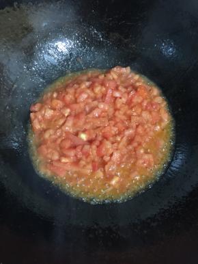 锅烧热倒入适量的油，放入西红柿丁翻炒片刻。