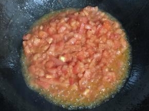 锅烧热倒入适量的油，放入西红柿丁翻炒片刻。