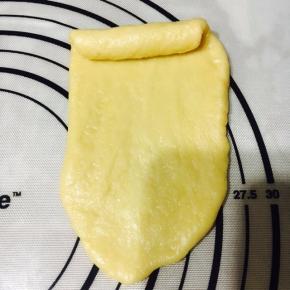 擀成长舌状，从一头卷起。