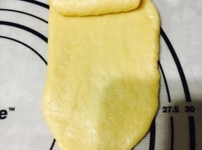 擀成长舌状，从一头卷起。