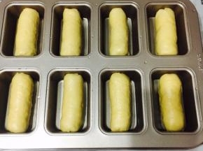 依次卷好放入学厨方形8连不沾模具中！进行第二次发酵，烤箱发酵35度，30分钟，底层放碗开水！