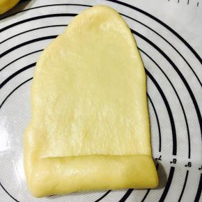 擀至长舌状，从一端卷起，收口。