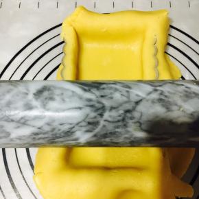 用擀面杖轻轻擀下多余的面皮。