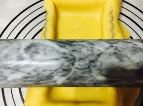 用擀面杖轻轻擀下多余的面皮。