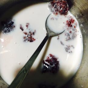 接下来制作慕斯馅，把牛奶和覆盆子果茸搅拌均匀。