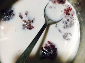 接下来制作慕斯馅，把牛奶和覆盆子果茸搅拌均匀。