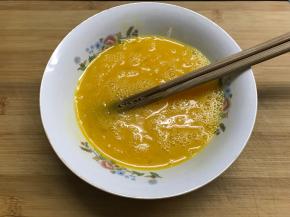 鸡蛋打在碗中。加入适量料酒和少许盐打散。