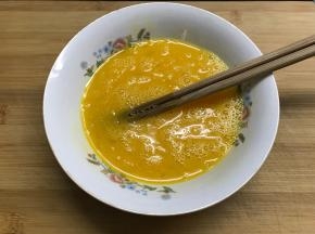 鸡蛋打在碗中。加入适量料酒和少许盐打散。
