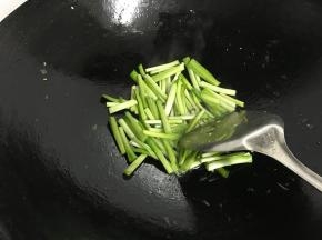 锅中再倒入适量油后先把韭菜茎放入煸炒。