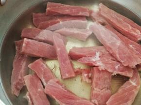 牛肉逆纹路切成长条，用清水泡两小时以上，期间用手挤压牛肉条，换水两次