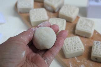 粘点熟粉在手心上，将包好的小球，在手心里轻轻地滚一下。
