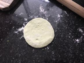 将剂子擀成中间厚边上薄的包子皮。