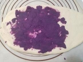 将松弛好的面团擀成一个长方形的面片，将紫薯馅铺满三分之二。