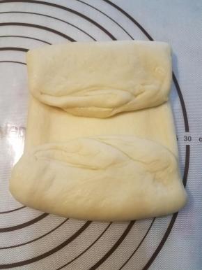 两端向中间翻折。中间要留一条缝隙，这样继续折叠的时候面团不会相互挤压。