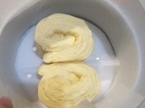 卷成长条形的卷状，两两一组，排入模具中（不沾模可以不用处理，普通模具我垫了油纸防粘）。卷的时候，特别是边上那两条，要特别注意方向。成对的两条是相对方向的，也就是说一条从左往右卷，一条从右往左卷。