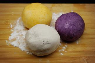 木薯粉分成三等分，分别加入紫芋泥、紫薯泥、南瓜泥中，煮沸的糖水拌均，揉成三个颜色的光滑团；