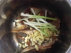 放入蒜瓣，姜末，八角，桂皮，香叶，花椒，葱白，干辣椒。