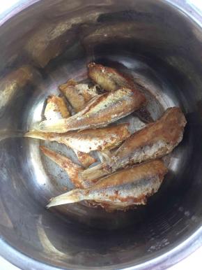 把煎好的鱼放进电压力锅中。