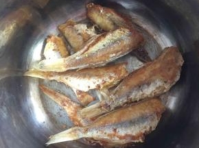 把煎好的鱼放进电压力锅中。