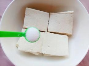 切好的豆腐装碗加入一勺盐