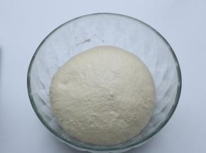 取出面团揉一揉，撕成小块，放入面包桶底层。