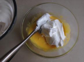 将1/3打发好的蛋白霜放入蛋黄糊里，用刮刀从底部向上翻拌兼切拌均匀