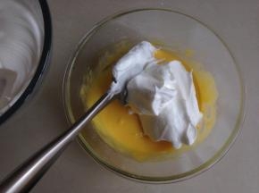 将1/3打发好的蛋白霜放入蛋黄糊里，用刮刀从底部向上翻拌兼切拌均匀