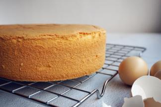 烘烤结束，将蛋糕取出，在桌面上摔一下，震出里面的热气，立即倒扣，待蛋糕完全放凉后才脱模哟