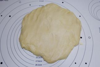 发酵好的面团取出，按压排气，边缘的大气泡拍掉。