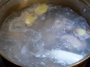 锅中加入水，姜片，1勺料酒煮沸，放入猪手焯水。