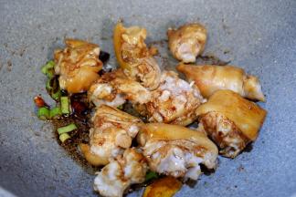 加入猪手，生抽，老抽，料酒，翻炒至猪手上色。