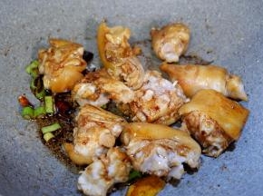 加入猪手，生抽，老抽，料酒，翻炒至猪手上色。