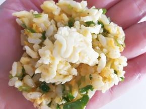 挖一勺米饭混合物，用手压扁，中间放一点至少碎