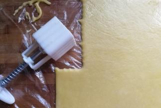 擀好后将保鲜膜剪开，用饼干模具或月饼模具开始压模（有饼干模具最好，我没有印花饼干模具，就用月饼模具代替）
