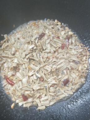 倒入腊鸭肠煸炒一会，再把腌制腊鸭肠的料酒倒入。