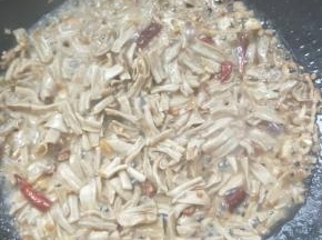 倒入腊鸭肠煸炒一会，再把腌制腊鸭肠的料酒倒入。