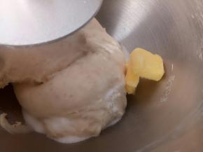 这时就可以放入盐和软化好的黄油了。继续揉。