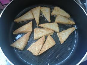 锅热倒油，裹了蛋液的豆腐下锅煎至两面金黄，盛出待用。