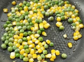 锅中余油，倒入青豆玉米粒。
