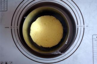 6寸的加高慕斯圈底部包上一层保鲜模或锡纸，将模具放在碟子上，放入一片蛋糕片。