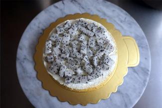 将一片蛋糕片放在纸托上，然后抹上淡奶油，摆上水果，再填上淡奶油，抹平整表面。