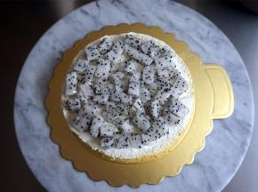 将一片蛋糕片放在纸托上，然后抹上淡奶油，摆上水果，再填上淡奶油，抹平整表面。