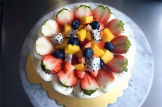 将芒果丁，草莓丁，火龙果丁，奇异果丁，蓝莓铺放在蛋糕中央，如图。