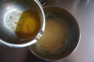 从烤箱取出融化的黄油加入到面糊中（黄油表面有点焦化，如有黑点，可以先过滤后加入），拌至黄油完全融合。