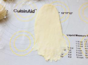 取一个面团，擀成牛舌型，翻面，底部搓薄