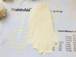 取一个面团，擀成牛舌型，翻面，底部搓薄